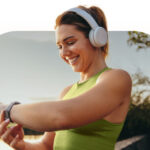 A woman looking down at her watch and smiling.