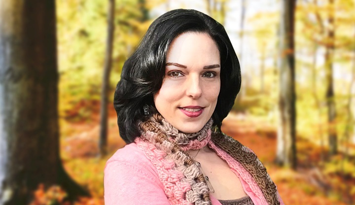 An image of Psychic Elise, a woman with pale skin and shoulder-length black hair. She is wearing a pink shirt and a scarf.