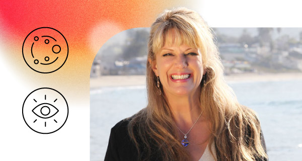 An image of Psychic Monique, a smiling woman with long blonde hair. There is a body of water behind her.