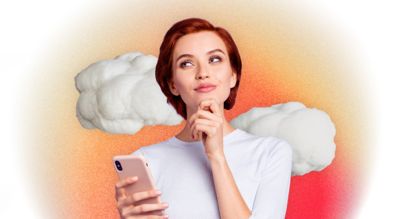 An image of a woman with red hair, holding her phone with one hand and resting her other hand on her chin.