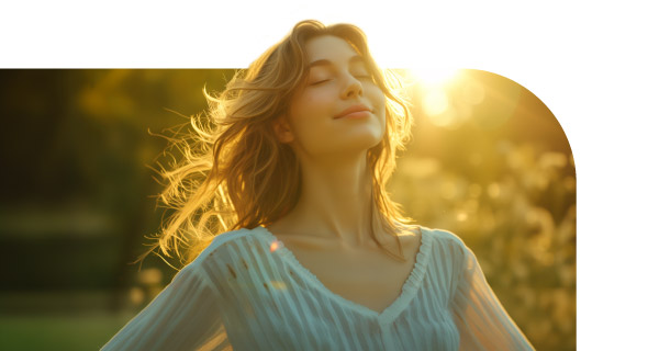 A woman outside, enjoying the evening sun and breeze.