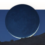 A dark silhouette of a moon over a hill.