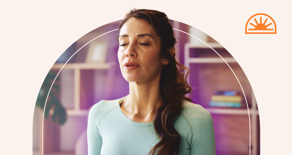 A woman meditating with an indigo aura emanating out from her.