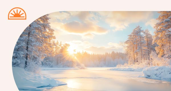 A snowy landscape with a sun setting over the ice.