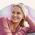 A woman with a pink aura smiling.