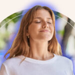 A woman meditating with her blue aura emanating from around her.