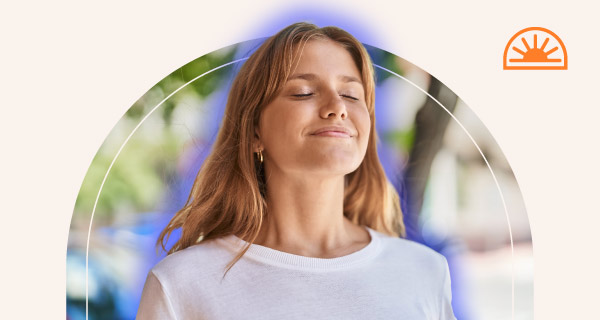 A woman meditating with her blue aura emanating from around her.