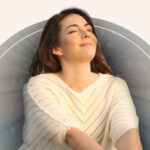 A woman meditating with a gentle black aura emanating from her.