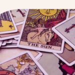 A deck of Tarot cards scattered on someone's desk.