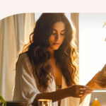 A woman sitting at her table with a laptop in front of her.