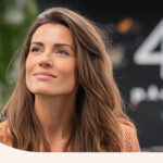 A woman in an office setting, with the number 4 written on a blackboard behind her.