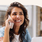 A woman in the office speaking on the phone.