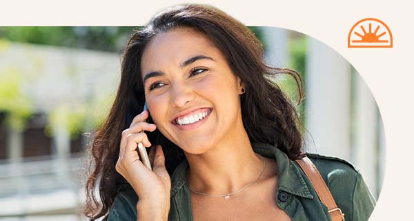 A woman talking on the phone while on a walk.