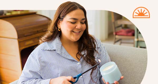 A woman lighting a candle in her living room